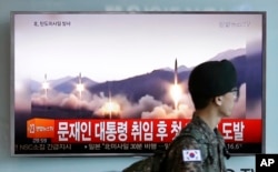 A South Korean army soldier walks by a TV news program showing a file image of missiles being test-launched by North Korea, at the Seoul Railway Station in Seoul, South Korea, May 14, 2017.