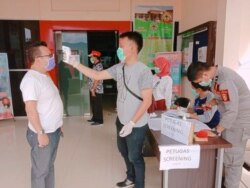 Petugas melakukan pemeriksaan suhu tubuh terhadap warga yang mendatangi RSUD Morowali Utara untuk mengikuti rapid test, 4 April 2020. (Foto; Courtesy/Ivan Tagora)