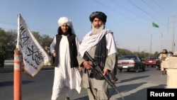 Seorang pejuang Taliban tampak memegang senapan serbu M16 berdiri di luar Kementerian Dalam Negeri di Kabul pada 16 Agustus 2021.(Reuters)