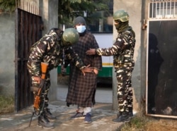 FILE - Indian soldiers frisk a voter as he arrives to cast his vote during the first phase of District Development Councils election on the outskirts of Srinagar, Indian controlled Kashmir, Nov. 28, 2020.