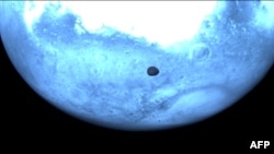 The surface of Mars and the face of Deimos, the smaller and more mysterious of Mars’ two moons, are photographed on March 12 by the European Space Agency’s HERA mission. (ESA via AFP)