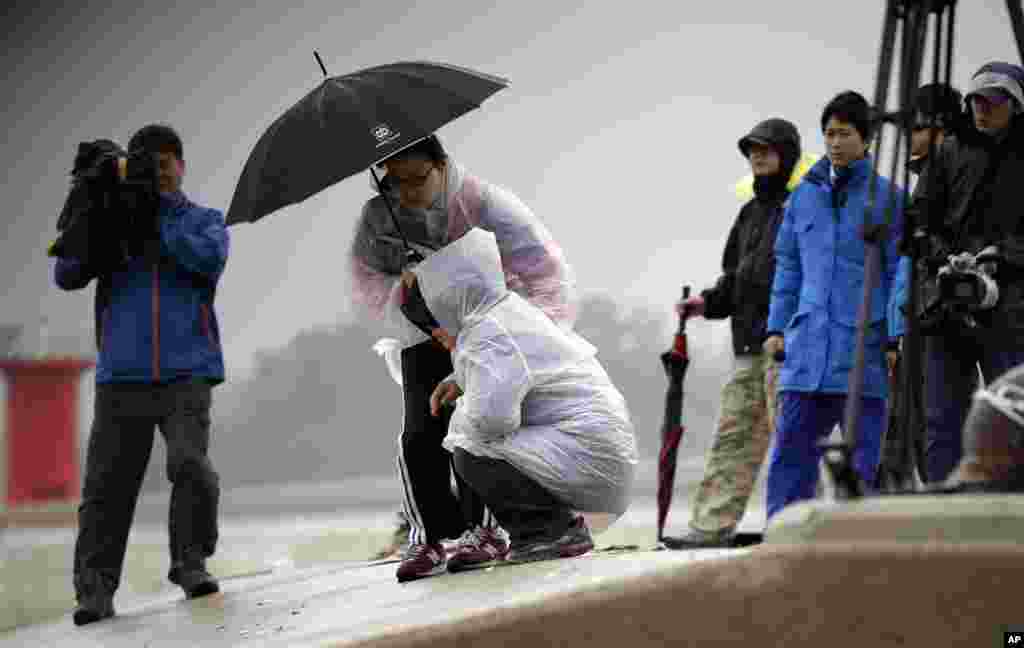 Thân nhân của hành khách trên chiếc phà bị lật ngồi khóc tại bến cảng Jindo.