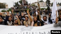 Para pejuang Taliban memegang bendera Emirat Islam Afghanistan pada peringatan satu tahun Taliban kembali berkuasa pasca penarikan pasukan internasional, dalam upacara di Kabul, Afghanistan, 15 Agustus 2022.