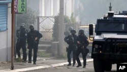Pripadnici kosovske policije u akciji na ulicama severnog dela Kosovske Mitrovici (AP Photo/Bojan Slavkovic)