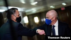 U.S. Senator Mitt Romney (R-UT) greets Alejandro Mayorkas, President-elect Joe Biden's nominee to lead the U.S. Department of Homeland Security, on Capitol Hill in Washington, January 19, 2021. 