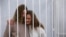Yekaterina Andreeva and Darya Chultsova, journalists working for the Polish television channel Belsat, embrace inside a defendants' cage during a court hearing in Minsk, Belarus, Feb. 9, 2021.