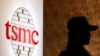 Seorang petugas keamanan berdiri di dekat logo Taiwan Semiconductor Manufacturing Co. Ltd (TSMC) di Taipei. (Foto: REUTERS/Pichi Chuang)