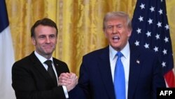 Le président américain Donald Trump et le président français Emmanuel Macron se serrent la main à la fin d'une conférence de presse conjointe dans la salle Est de la Maison Blanche à Washington, DC, le 24 février 2025. (Photo by ROBERTO SCHMIDT / AFP)
