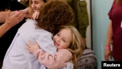 កុមារី Amelia Aloni ឱប​មនុស្ស​ម្នាក់ ខណៈ​ដែល​នាង​និង​ម្ដាយ​របស់​នាងឈ្មោះ Daniel ​ជួបសមាជិក​គ្រួសារ​របស់​ខ្លួន បន្ទាប់ពី​ក្រុម​ហាម៉ាស់​ដោះលែង​ពួកគេ នៅ​ក្នុង​កិច្ចព្រមព្រៀង​បទឈប់បាញ់​ជា​បណ្ដោះអាសន្ន​រវាង​អ៊ីស្រាអែល​និង​ក្រុម​ហាម៉ាស់ ថ្ងៃទី ២៥ ខែវិច្ឆិកា ឆ្នាំ២០២៣។