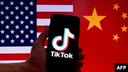 Logo aplikasi media sosial TikTok terlihat di layar iPhone dengan latar belakang bendera Amerika Serikat dan China di Washington, DC, pada 16 Maret 2023. (Foto: AFP)