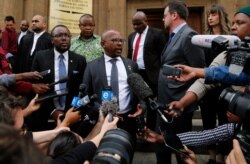 Nelson Mandela Foundation CEO Sello Hatang (C) speaks to the press on the steps of the Johannesburg High Court, Aug. 21, 2019.