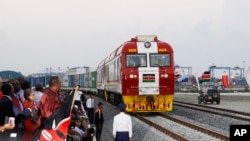 Warga Kenya menyaksikan kereta kargo SGR meninggalkan Mombasa menuju Nairobi, 30 Mei 2017. Proyek ini merupakan investasi senilai $3,3 miliar yang didukung China. Namun, studi menunjukkan jumlah pinjaman China ke Afrika kini telah menurun tajam.