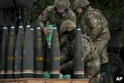 Tentara Inggris menyiapkan peluru senjata artileri self-propelled AS-90 selama latihan militer Kamp Musim Dingin 23 di dekat Tapa, Estonia, Selasa, 7 Februari 2023. (Foto: AP)