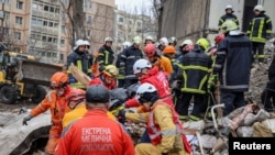 乌克兰救援人员在敖德萨被毁楼房废墟中移出一具尸体。（2024年3月2日）