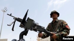 Seorang anggota pasukan keamanan Afghanistan berjaga-jaga di dalam kendaraan tentara di pangkalan udara AS Bagram, setelah pasukan Amerika mengosongkannya, di Provinsi Parwan, Afghanistan, 5 Juli 2021. (Phoro: REUTERS/Mohammad Ismail)