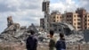 Mladići u Gazi posmatraju ruševine u mestu Asra (Foto: AFP)