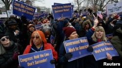 FILE - Labor union activists rally in support of federal workers during a protest in Washington, Feb. 11, 2025. Despite the protests, President Donald Trump signed an executive order Tuesday telling agency leaders to plan for "large-scale reductions in force." 