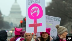 来自全国各地的成千上万的男女民众星期六冒着刺骨寒风和冷雨在华盛顿街头集会