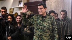 Komandan Pasukan Demokratik Suriah (SDF) Mazloum Abdi melambaikan tangan setelah memberi keterangan pers di Kota Hasakeh, Suriah, 6 Desember 2024 (Foto: Deili Souleman/AFP)