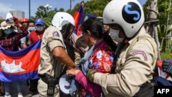 កងសន្ដិសុខ​រឹបអូស​ឧបករណ៍​បំពង​សំឡេង​ពី​បាតុករ​ម្នាក់ ក្នុង​អំឡុងពេល​នៃ​ការ​ធ្វើ​បាតុកម្ម​មួយ​ដើម្បី​ប្រារព្ធ​ខួប​ទី​២៩ នៃ​កិច្ចព្រមព្រៀង​សន្ដិភាព​ទីក្រុង​ប៉ារីស​នៅ​មុខ​ស្ថានទូត​សហរដ្ឋអាមេរិក រាជធានី​ភ្នំពេញ ​ថ្ងៃទី២៣ ខែតុលា ឆ្នាំ២០២០។