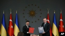 Presiden Turki Recep Tayyip Erdogan, kanan, dan Presiden Ukraina Volodymyr Zelenskiy berpose untuk foto setelah mereka menandatangani perjanjian, di Istanbul, 16 Oktober 2020. (Foto: AP)