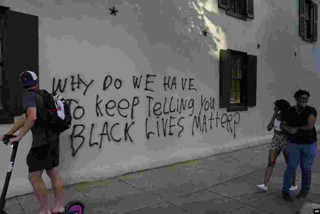 អ្នកដើរ​ឆ្លងកាត់​ក្បែរ​កន្លែង​ធ្វើបាតុកម្ម​បាន​អាន​សំណេរ​មួយ​ដែល​សរសេរ​លើ​ជញ្ជាំង​ថា &laquo;តើ​ហេតុអ្វី​បាន​ជា​យើង​ត្រូវ​បន្ត​ប្រាប់​អ្នក​ថា ជីវិត​របស់​ពលរដ្ឋ​ស្បែក​ខ្មៅ​មាន​សារៈសំខាន់?&raquo; នៅ​ពេល​ក្រុមបាតុករ​ប្រមូល​ផ្តុំគ្នា​ដើម្បី​តវ៉ា​អំពី​ការស្លាប់​របស់​លោក George Floyd នៅ​ថ្ងៃសៅរ៍​ទី ៣០ ខែឧសភា ឆ្នាំ ២០២០ ក្បែរ​សេតវិមាន​ក្នុង​រដ្ឋធានី​វ៉ាស៊ីនតោន។ (AP) 