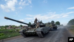 在靠近俄乌边界的乌克兰苏梅州，从俄罗斯境内返回的乌克兰军人坐在坦克顶上。(2024年8月15日)