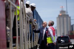 FILE - U.S. President Joe Biden and Chief Operating Officer of Lobito Atlantic Railway Nicolas Gregoire meet rail workers during a tour of the Lobito Port Terminal in Lobito, Angola, Dec. 4, 2024.