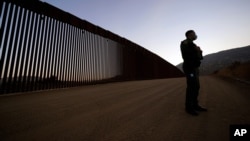 Arhiva - Pripadnik granične patrole ispred zamenjenog dela granične baijere, 24. septembra 2020.