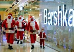 Warga mengenakan kostum Sinterklas saat berjalan-jalan di pusat perbelanjaan di tengah pandemi COvid-19 di Jakarta, 20 Desember 2020. (REUTERS/Ajeng Dinar Ulfiana)