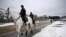 Mounted police ride past a security fence in Washington, DC, on January 18, 2025, as the US capital prepares for the inauguration of US President-elect Donald Trump January 20. (Photo by ANDREW CABALLERO-REYNOLDS / AFP)