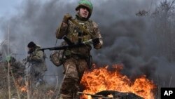 In this photo provided by Ukraine's 65th Mechanised Brigade press service on Jan. 8, 2025, a Ukrainian serviceman trains at the polygon in the Zaporizhzhia region, Ukraine.