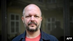 ທ່ານ ມາຕຸສ ຄອສໂຕລນີ ຫົວຫນ້າບັນນາທິການຂອງໜັງສືພິມອິດສະຫຼະ Dennik N, ຕັ້ງທ່າໃນລະຫວ່າງການຖ່າຍຮູບ ໃນ ນະຄອນຫຼວງ ບຣາຕິສລາວາ ຂອງສະໂລວາເກຍ ໃນວັນທີ 18 ພຶດສະພາ 2024. 