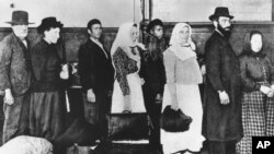 Grupa imigranata na ostrvu Elis čeka u redu na procesuiranje.