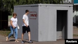 People walk past a reinforced-concrete bomb shelter installed on a street in Kursk, Russia, on Aug. 28, 2024. The sign on the structure reads, "Shelter."