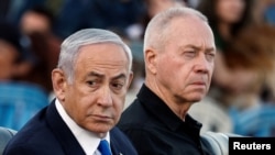 FILE - Israeli Prime Minister Benjamin Netanyahu, left, and Israeli Defense Minister Yoav Gallant attend a ceremony for the 70th cohort of military combat officers, at an army base near Mitzpe Ramon, Oct. 31, 2024. 
