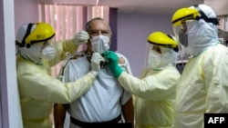 Di Panama, seorang pasien dengan kasus Covid-19 yang dikonfirmasi, dikelilingi oleh tim medis di unit perawatan intensif Rumah Sakit Paitilla di Panama City, 6 Mei 2020. (Foto: AFP)