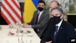 FILE - U.S. Secretary of State Antony Blinken, right, waits for the start of a meeting with Ukrainian Foreign Minister Dmytro Kuleba (seated opposite; not pictured), in Brussels, April 13, 2021. Blinken is due to meet with Kuleba in Kyiv next week.