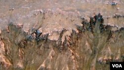 Gambar permukaan planet Mars yang dikirimkan oleh satelit pengamat NASA menunjukkan indikasi adanya air garam cair.
