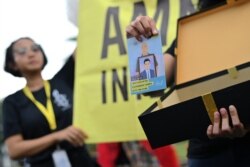 Seorang aktivis Amnesty International dalam demonstrasi di luar Istana Kepresidenan di Jakarta, 10 Desember 2019. (Foto: AFP)