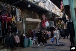 Sejumlah musliman berjalan di pasar di Kota Tua Yerusalem menjelang bulan puasa Ramadan, Kamis, 7 Maret 2024.(Foto: Leo Correa/AP Photo)