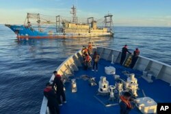 Sebuah kapal yang diduga milik milisi China menghalangi kapal penjaga pantai Filipina BRP Cabra saat mendekati Second Thomas Shoal di Laut Cina Selatan yang disengketakan pada 10 November 2023. (Foto: AP)