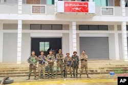 FILE - In this photo provided by Mandalay People's Defense, members of the Ta'ang National Liberation Army and Mandalay People's Defense resistance forces pose for a photograph in front of a captured building in Nawnghkio, Myanmar, on June 26, 2024.