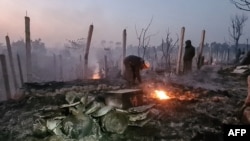 Sejumlah pengungsi Rohingya mengais-ais puing-puing rumah mereka yang hangus terbakar api di kamp Ukhia, Cox's Bazaar pada Minggu, 7 Januari 2024. (Foto: AFP)