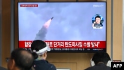 Warga menyaksikan layar televisi yang menampilkan siaran uji coba rudal Korea Utara, di sebuah stasiun kereta api di Seoul pada 22 April 2024.(Foto: AFP)