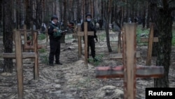 警察在新近收复的伊久姆镇附近的乱葬坟场进行检查。(2022年9月16日)