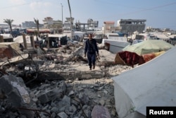 Palestinac Hamada Abu Sleima, čija su žena, šestoro dece i dvoje unučadi ubijeni u izraelskom udaru u kom je uništenja njihova kuća, hoda po ruševinama, u Rafi, na jugu Pojasa Gaze, 1. januara 2024.