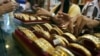 Picture taken on September 1, 2010 shows Myanmar vendors arranging a display of gold jewellery at a jewellery shop at Chinatown in downtown Yangon. Housewives huddle over jewellery counters in Yangon's bustling Chinatown -- but they do not have fashion o