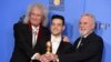 Personel band Queen, Brian May (kiri) dan Roger Taylor (kanan), mengapit Rami Malek, aktor terbaik dan peraih penghargaan film drama terbaik dalam film "Bohemian Rhapsody" pada ajang tahunan ke-76 Golden Globe Awards, di Beverly Hills, California, 6 Januari 2019.