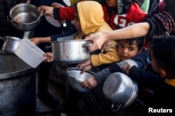 Anak-anak Palestina menunggu untuk menerima makanan yang dimasak oleh dapur amal di tengah kekurangan pasokan makanan di Rafah, di selatan Jalur Gaza, 5 Maret 2024. (Foto: REUTERS/Mohammed Salem)